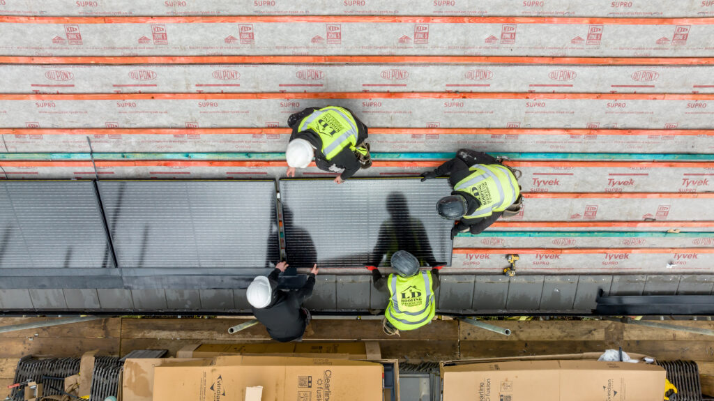 four team members installing solar panels