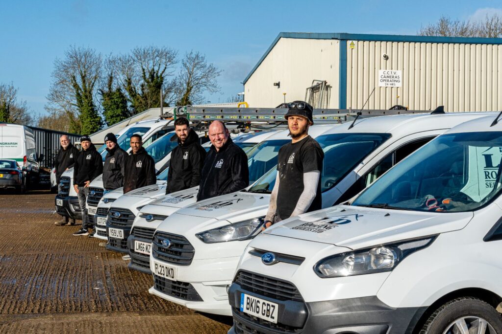 image of seven ld roofing employees standing next to their vans