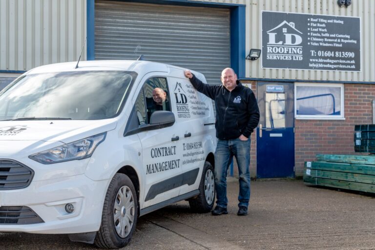 image of an ld roofing van with an employee leaning on it