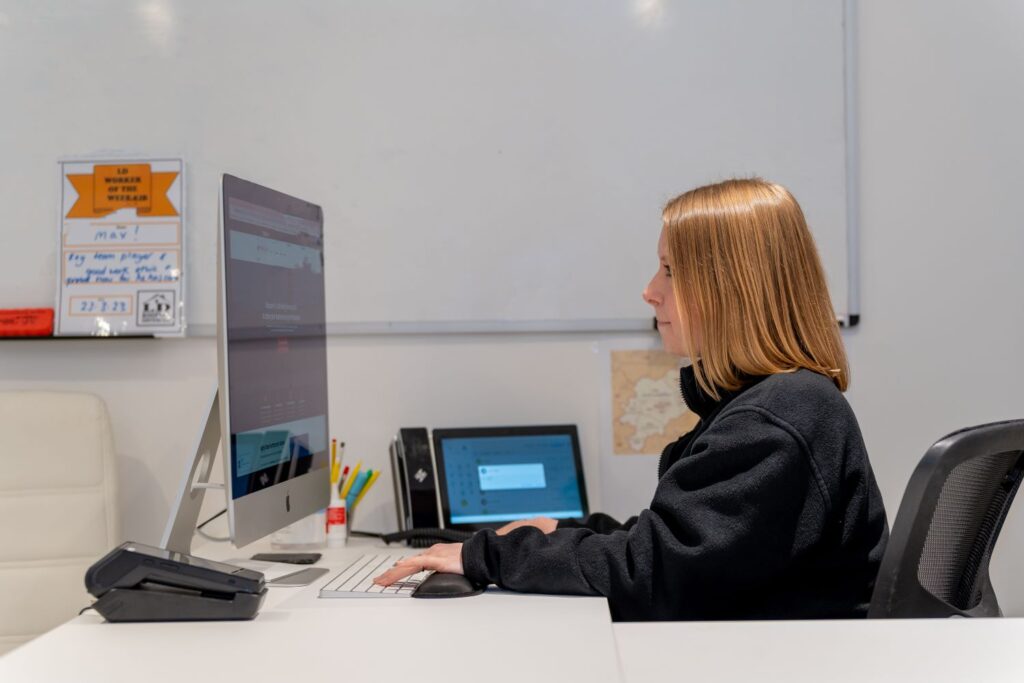 image of a woman sitting on a chair looking at a computer screen