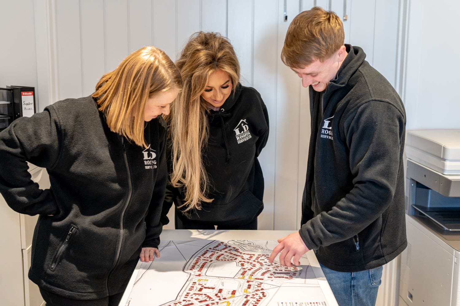 image of three ld roofing employees looking at a building map