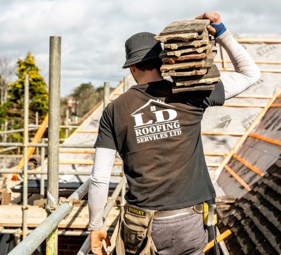 image of an ld roofing worker carrying tiles on his right shoulder