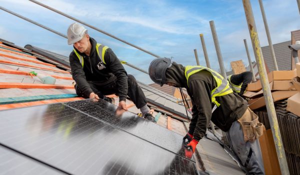 image of two men installing solar panels on a roof